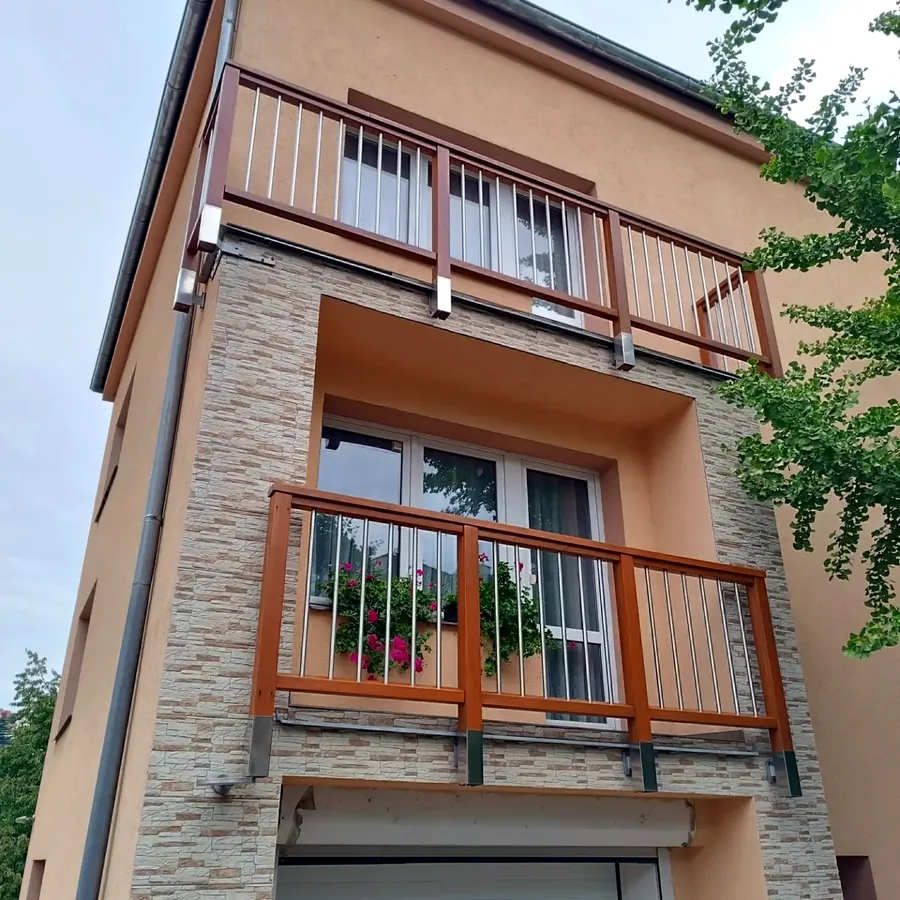 Obnovené dřevěné zábradlí balkonů na fasádě domu
