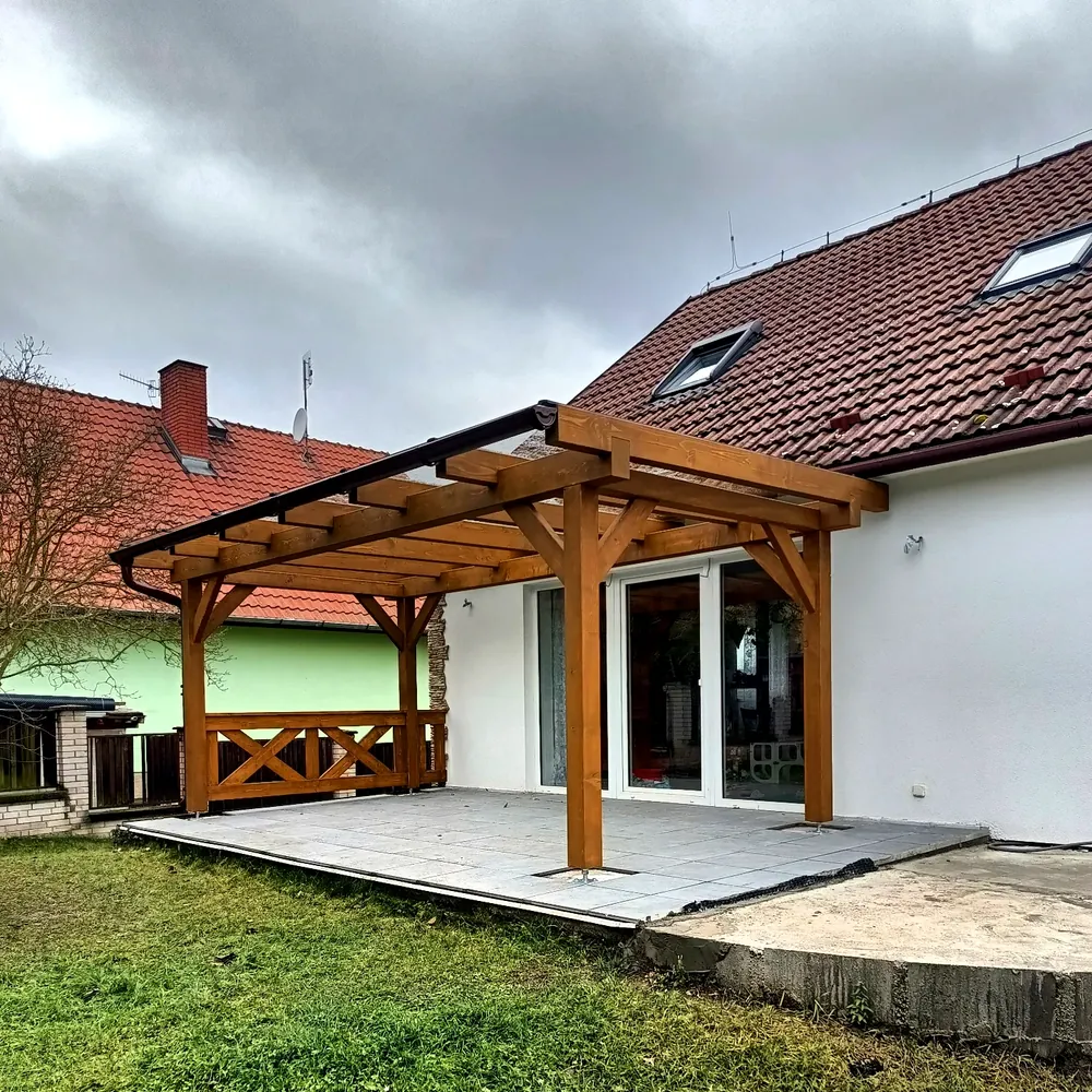 Pergola z hranolů se střechou z tvrzeného skla přistavěná k domu